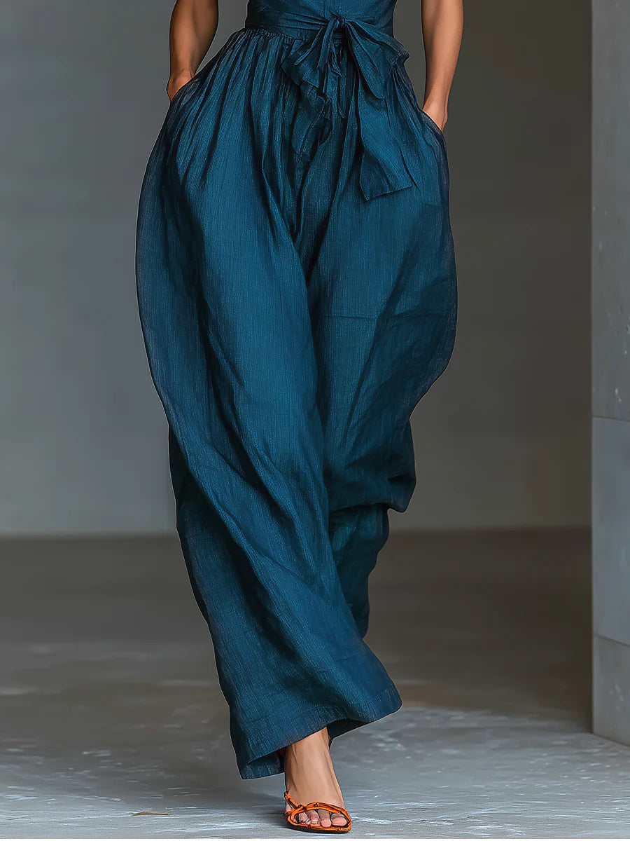 Mono azul marino con cuello halter cruzado, pierna ancha y bolsillos laterales