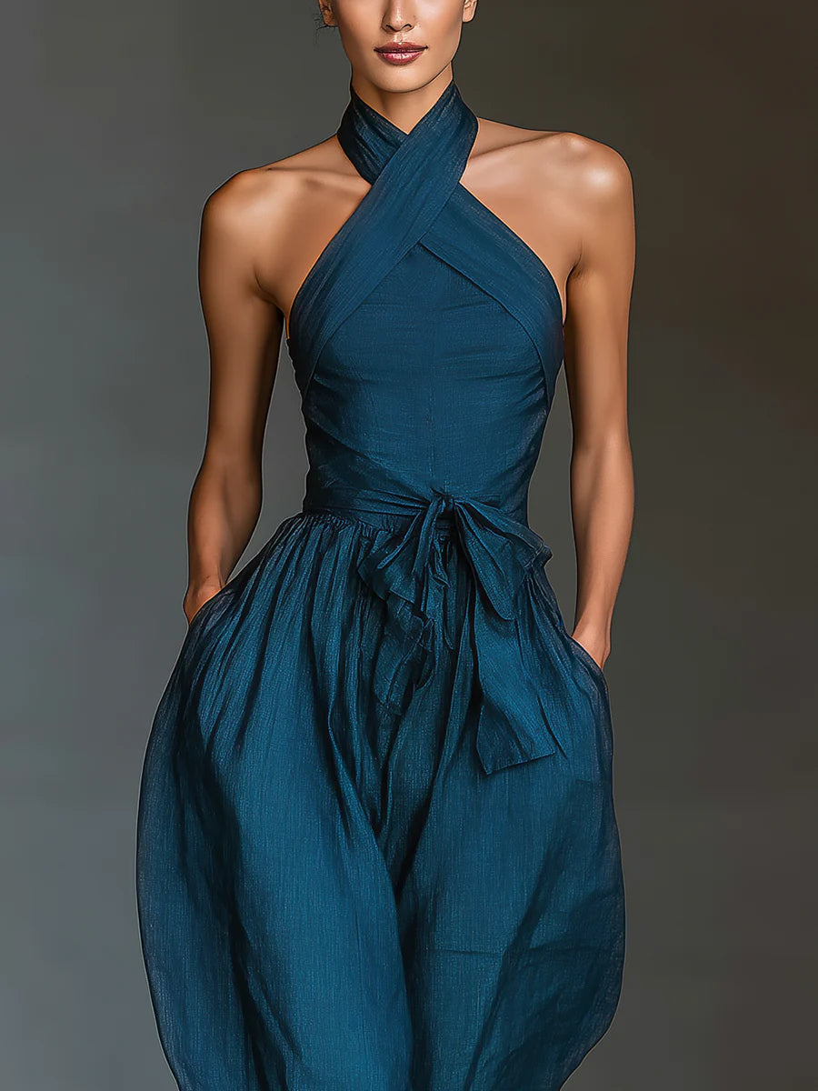 Mono azul marino con cuello halter cruzado, pierna ancha y bolsillos laterales