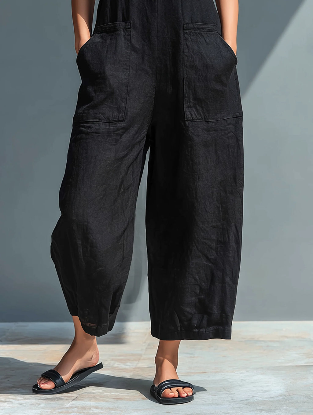 Mono negro minimalista efecto lino con cuello camisero, sin mangas y holgado